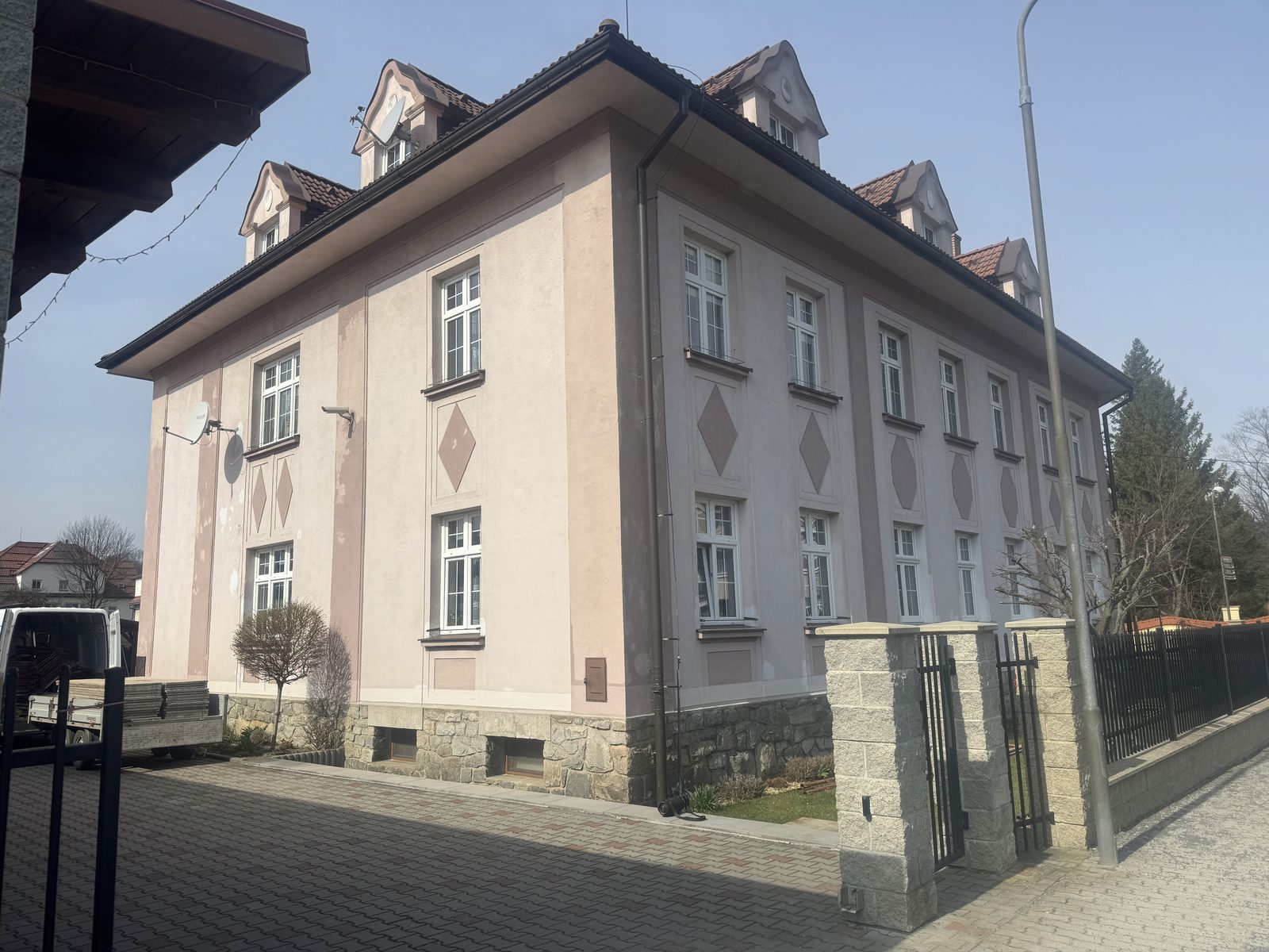 Zděný dům se starou růžovou fasádou před renovací